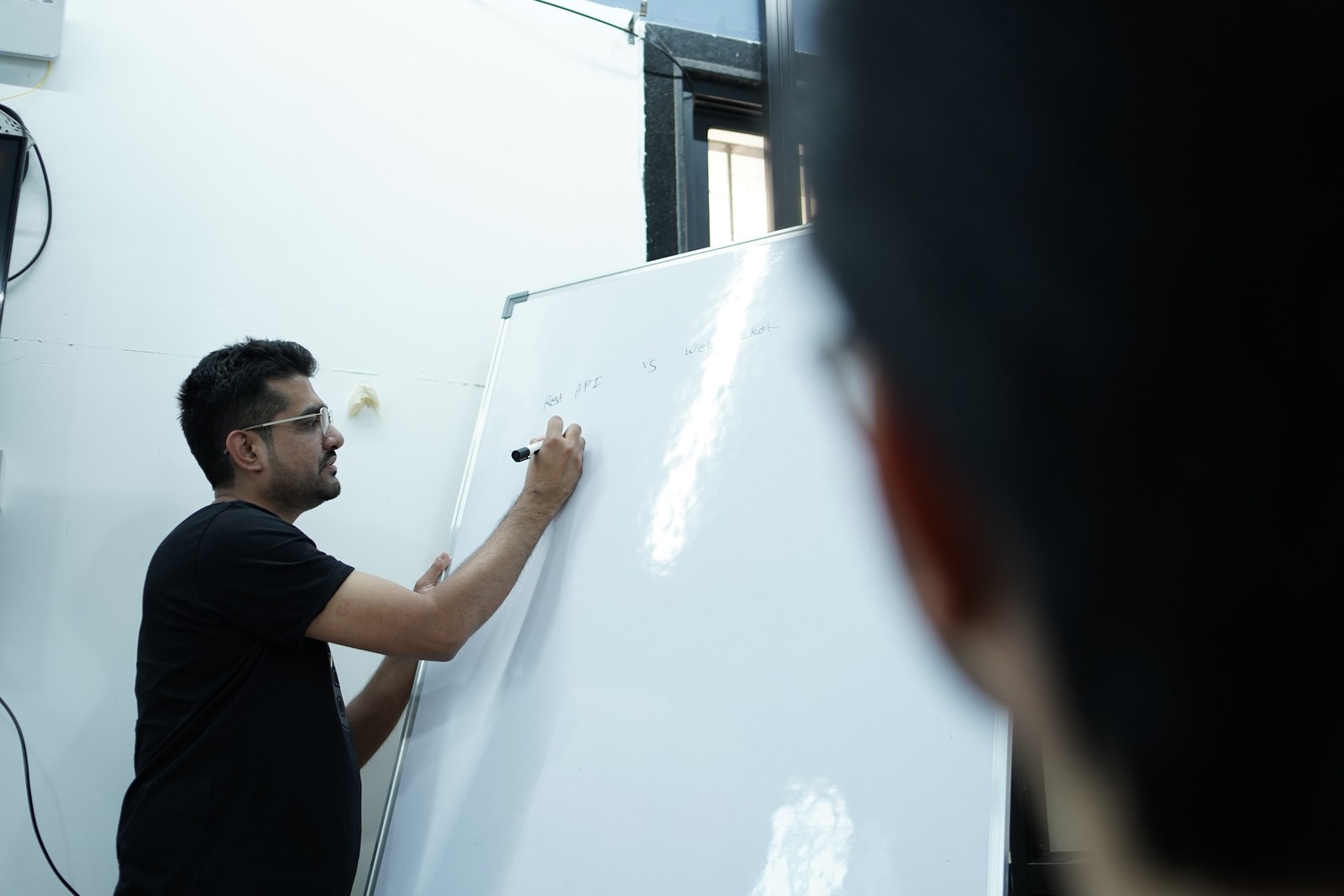 Faimsoft Academy mentor explaining a concept at the whiteboard